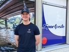 Kuvassa uunituoreita Titaanien t-paitoja, lippiksiä ja pipoja mainostava paikallinen miesmalli ei valitettavasti ainakaan vielä kuulu myytävien fanituotteiden joukkoon!